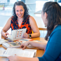 Gen Meredith, center, associate director of the Cornell Public Health Program, works with colleagues Zoe Wakoff, right, and Katie Lesser, left, in Schurman Hall.