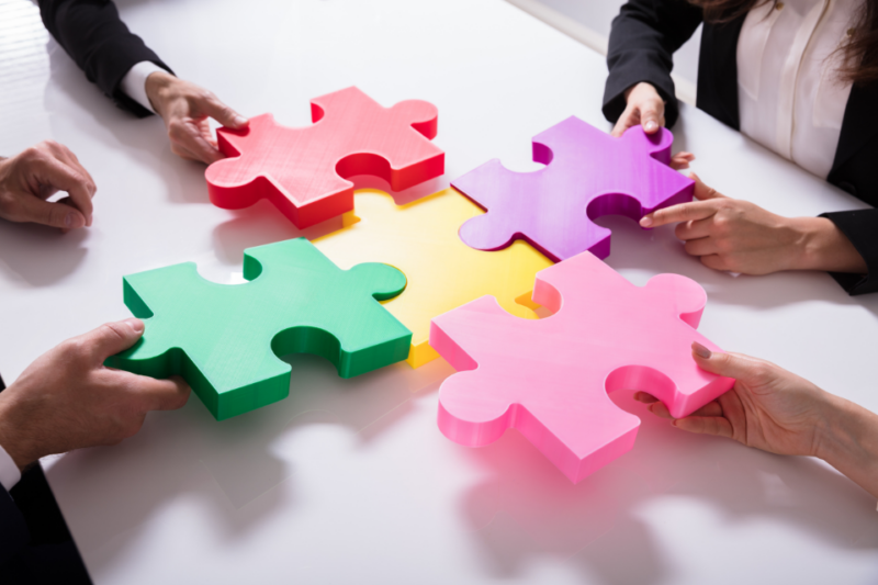 Employees connect colorful puzzle pieces