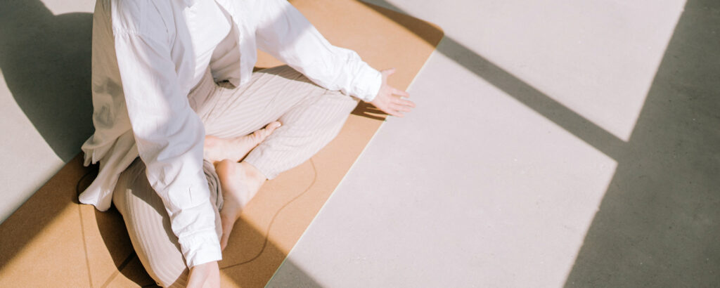 Person in light-colored clothing meditates