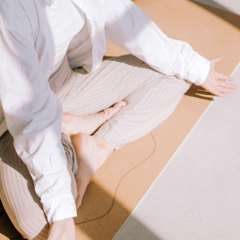 Person in light-colored clothing meditates